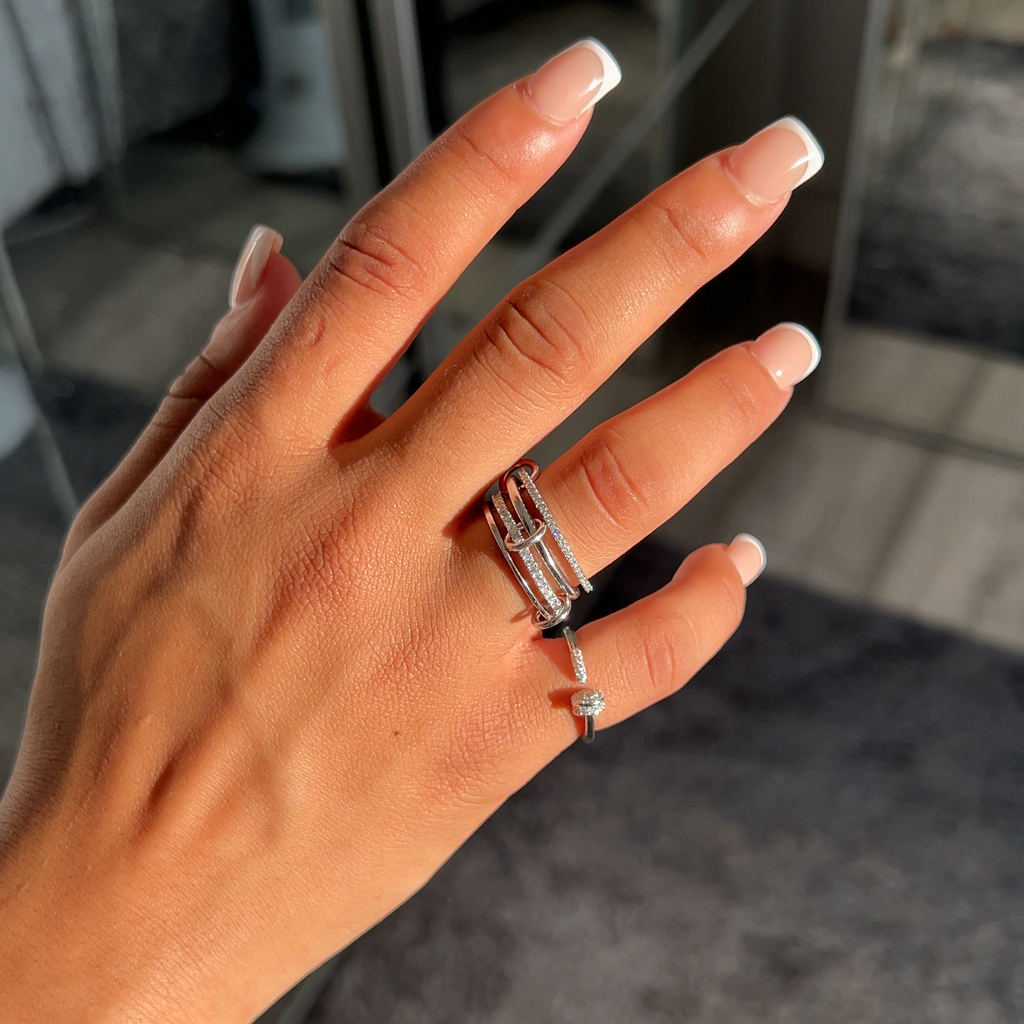 Rhodium plated Milla and Zaria rings worn on different fingers, sterling silver with pavé cubic zirconia, elegant layered jewellery styling.